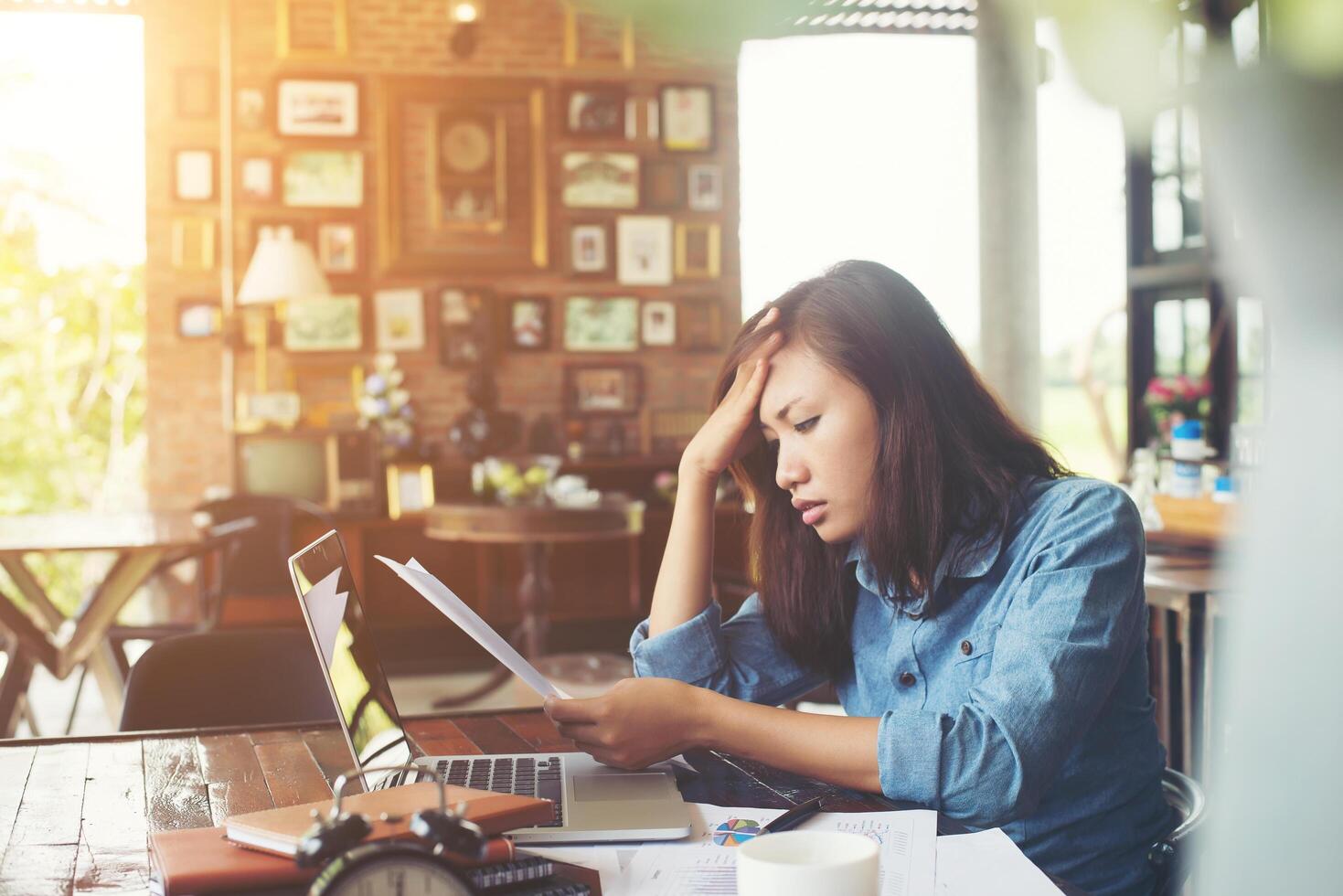 Young woman sitting in a cafe with her laptop, Stressful for work. photo