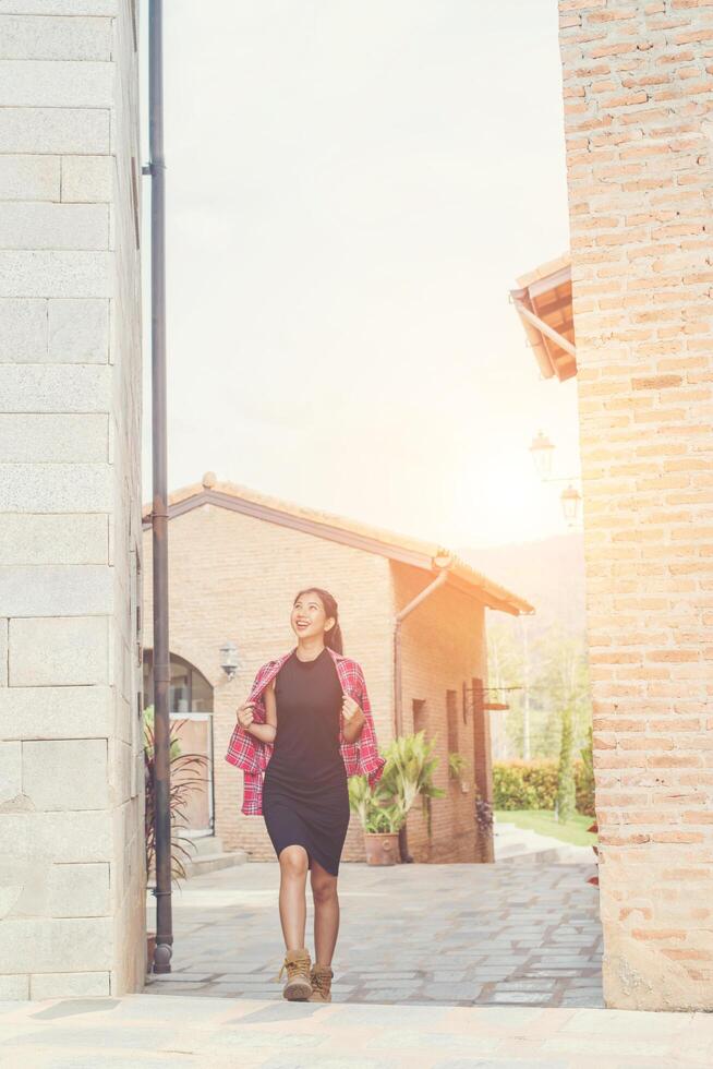 joven y bella mujer hipster caminando por la calle, vestida con una linda sonrisa a la moda, disfruta los fines de semana, viajando foto