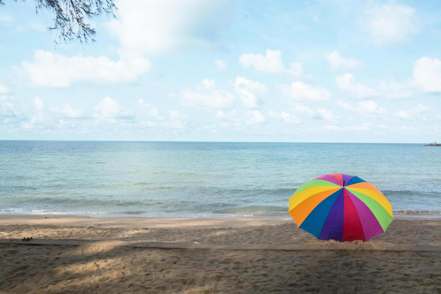 rainbow umbrella resting on the ground photo
