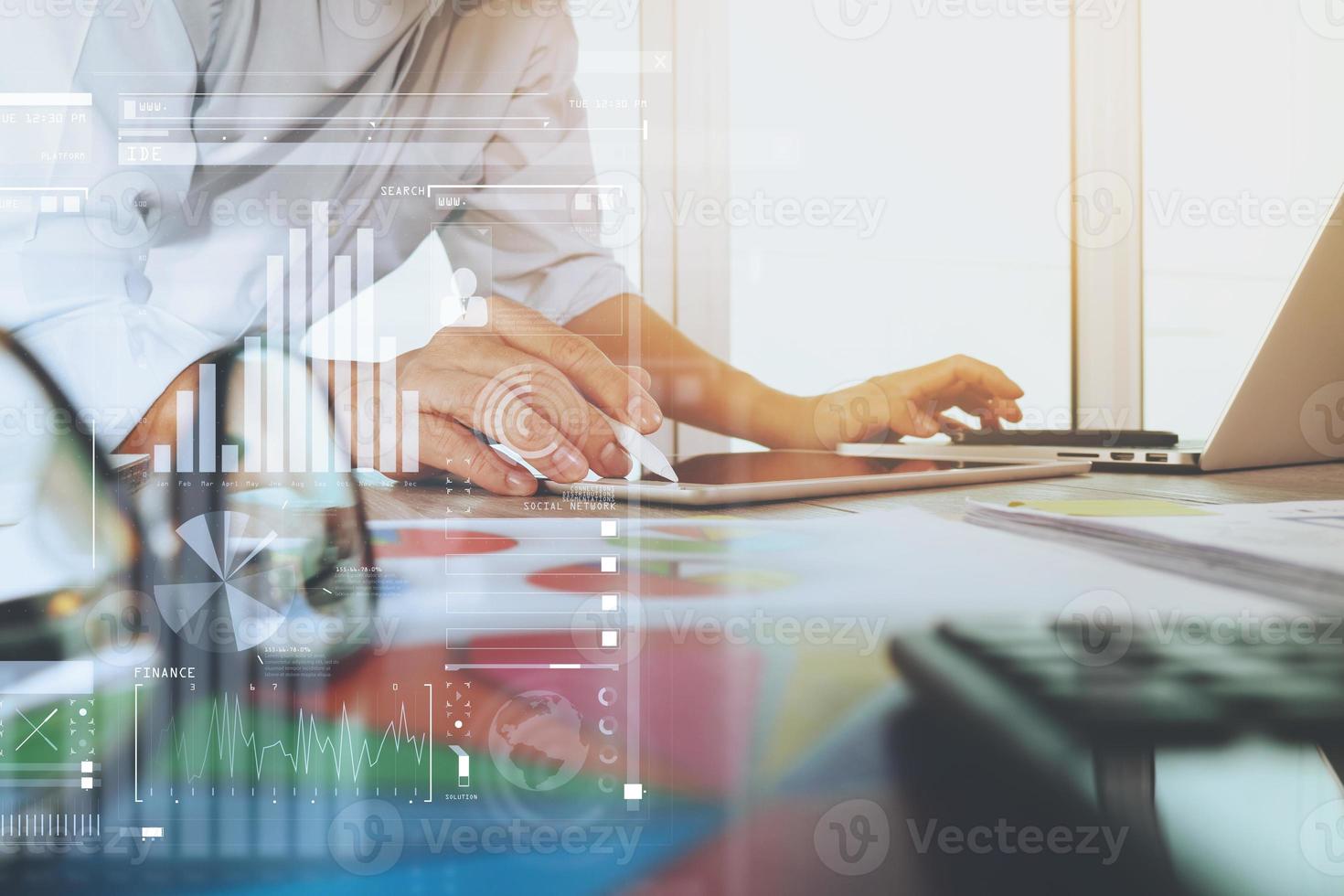 business documents on office table with laptop computer and graph business digital diagram and businessman working in the background photo