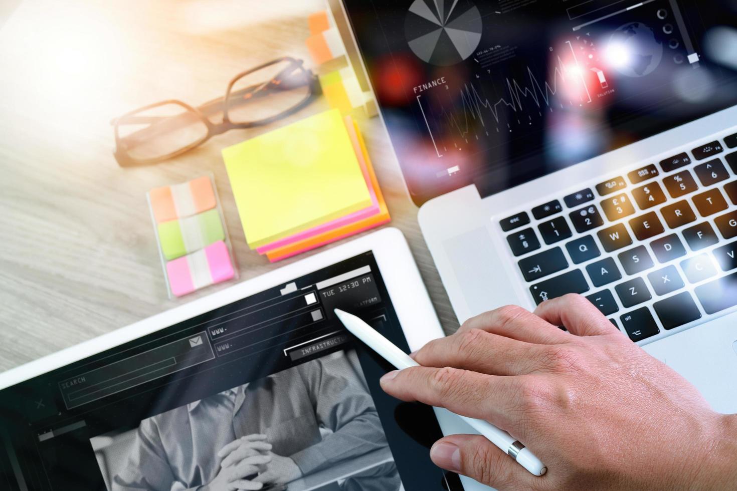 hombre de negocios que trabaja con una tableta digital y una nota de memo y una computadora portátil con efecto de capa de estrategia de negocios digital en el escritorio de madera como concepto foto