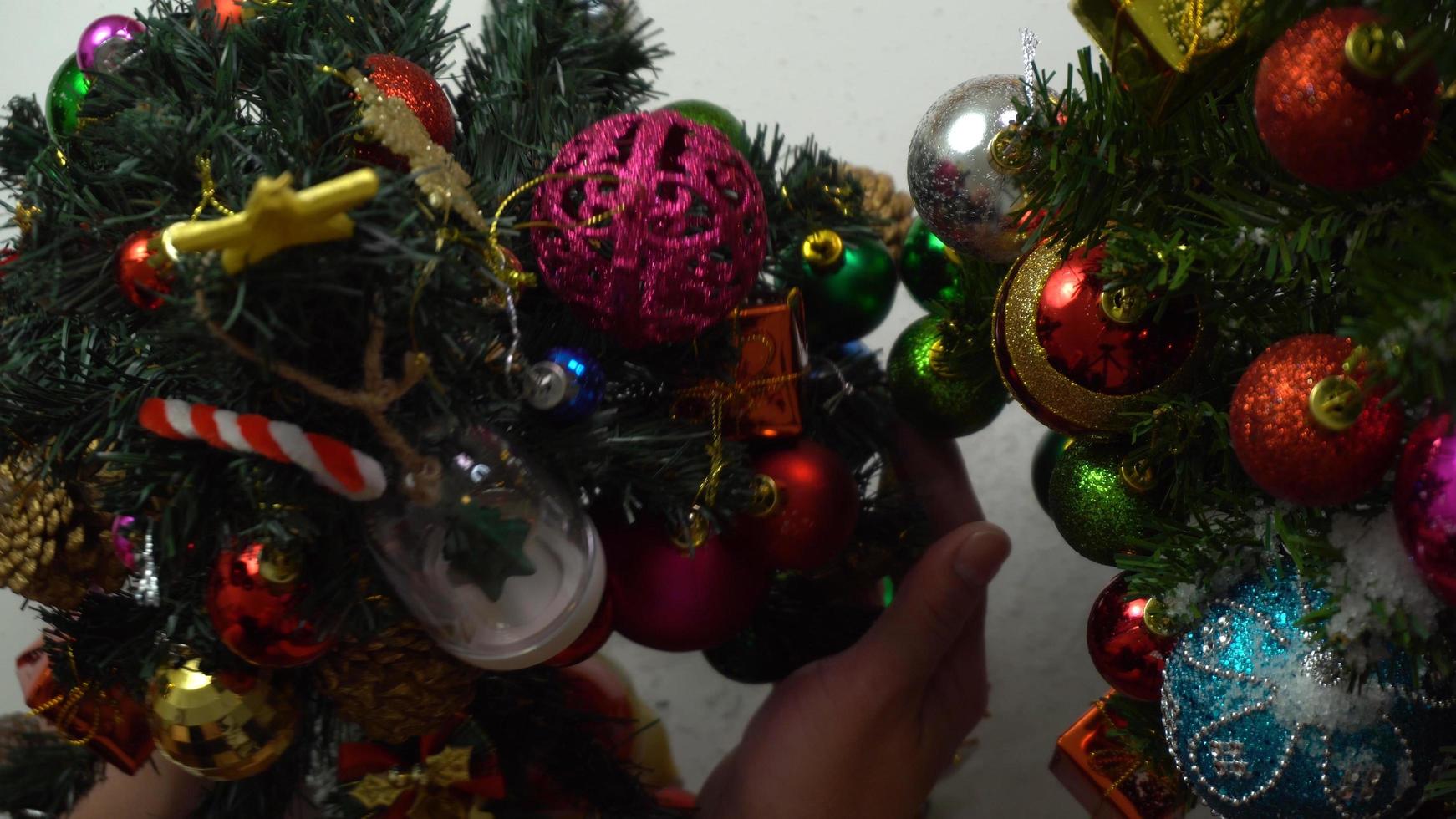 Greeting Season concept.hand setting of ornaments on a Christmas tree with decorative light photo