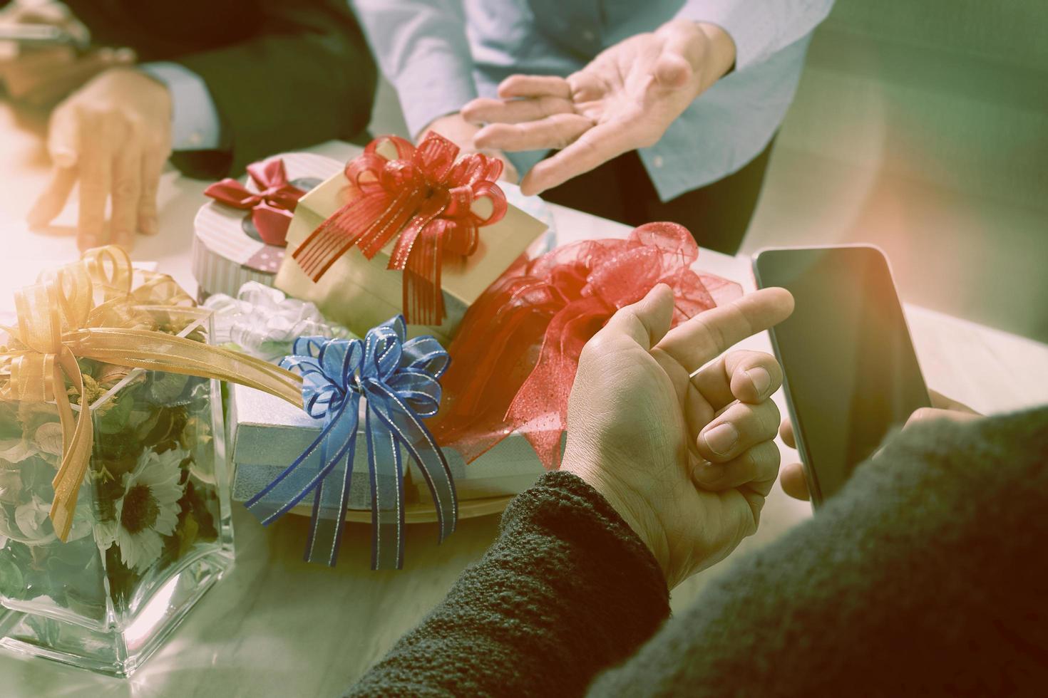 Gift giving Creative Hand using smart phone and co worker choosing gift. Gift delivery,office party,on marble meeting table,filter film effect photo