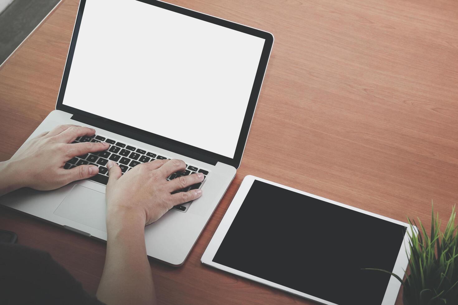 mano de hombre de negocios trabajando con una nueva computadora portátil moderna y una tableta digital profesional en un escritorio de madera como concepto foto