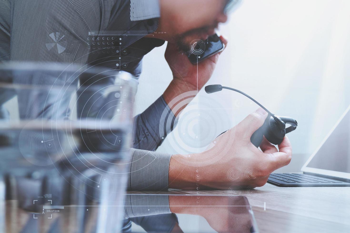 Man using VOIP headset with digital tablet computer docking smart keyboard, concept communication, it support, call center,digital screen graphic virtual icons,graph,diagram photo