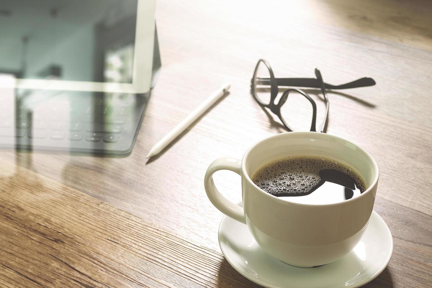 taza de café y teclado inteligente de base de mesa digital, anteojos, lápiz óptico en mesa de madera, efecto de filtro foto