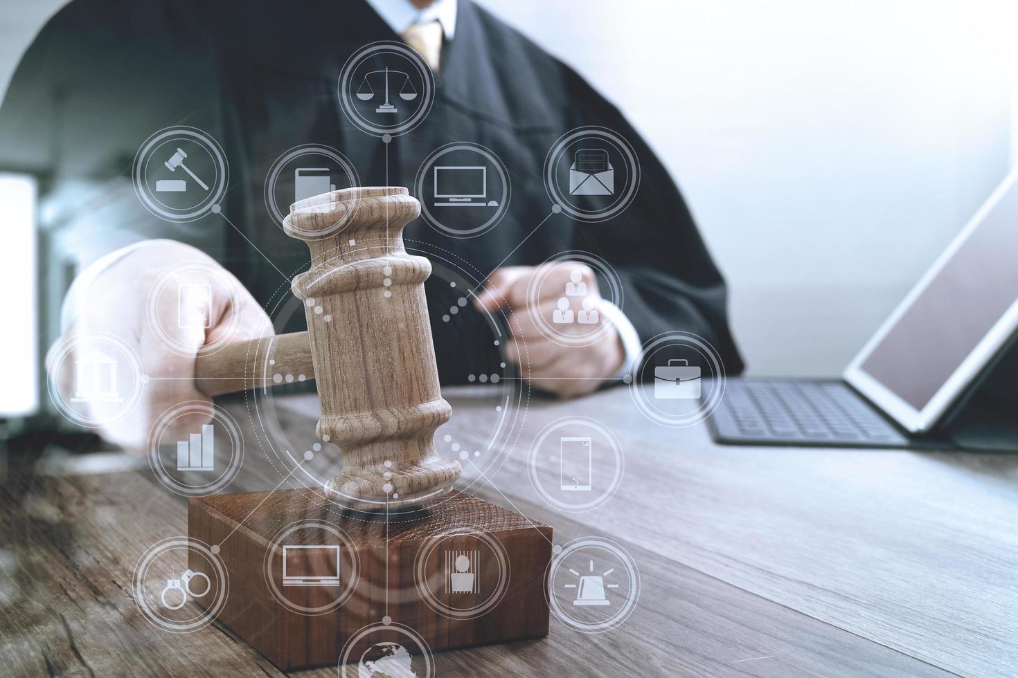 justice and law concept.Male judge in a courtroom striking the gavel,working with digital tablet computer docking keyboard on wood table,virtual interface graphic icons diagram photo