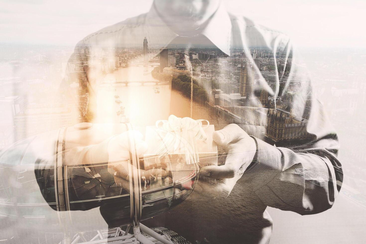 gift giving,businessman hand holding a gift box in a gesture of giving with London building,London eye,front view,filter effect photo