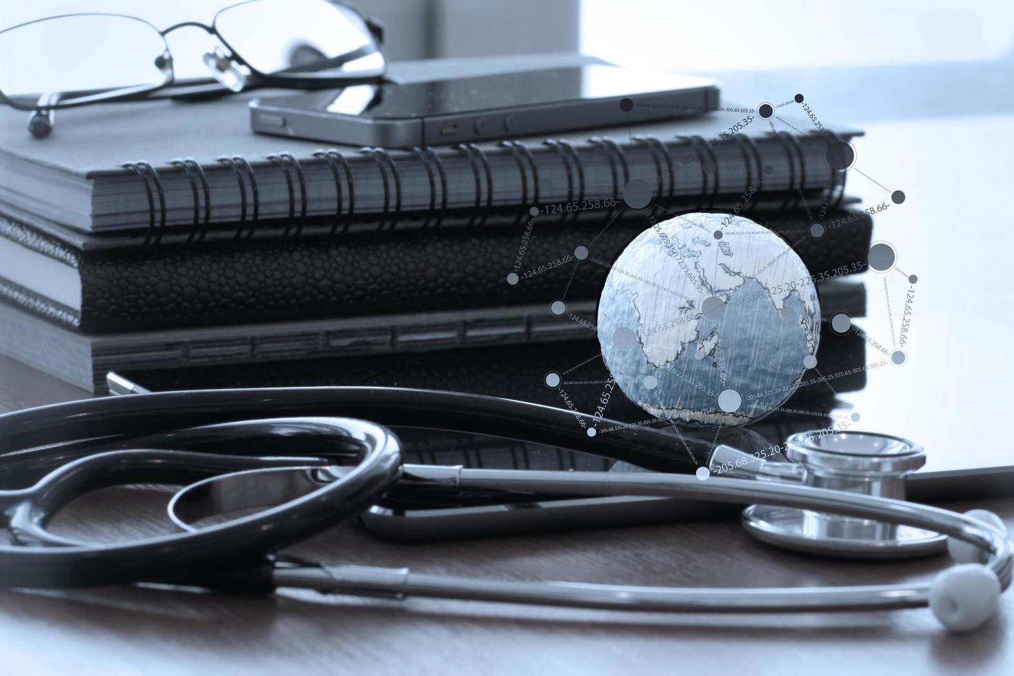 stethoscope and texture globe with digital tablet as medical network concept photo