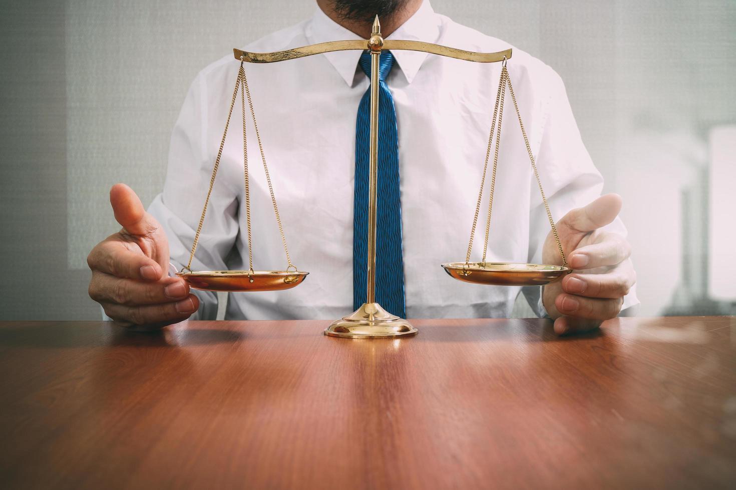 justice and law concept.Male lawyer in the office with brass scale on wooden table,reflected view photo