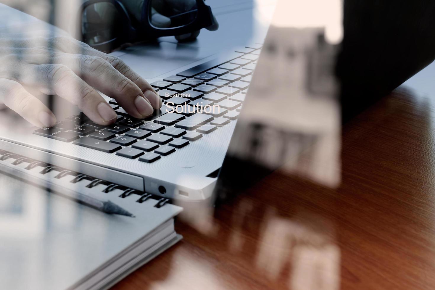 doble exposición de la mano de un hombre de negocios que trabaja con una nueva computadora moderna y una estrategia empresarial como concepto foto