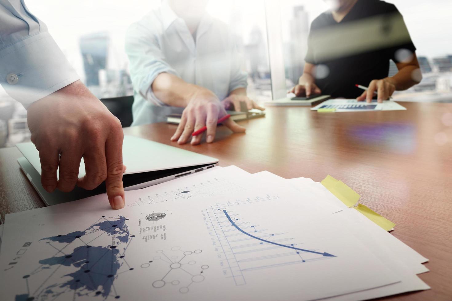 business documents on office table with smart phone and laptop computer and graph business with social network diagram and man working in the background photo