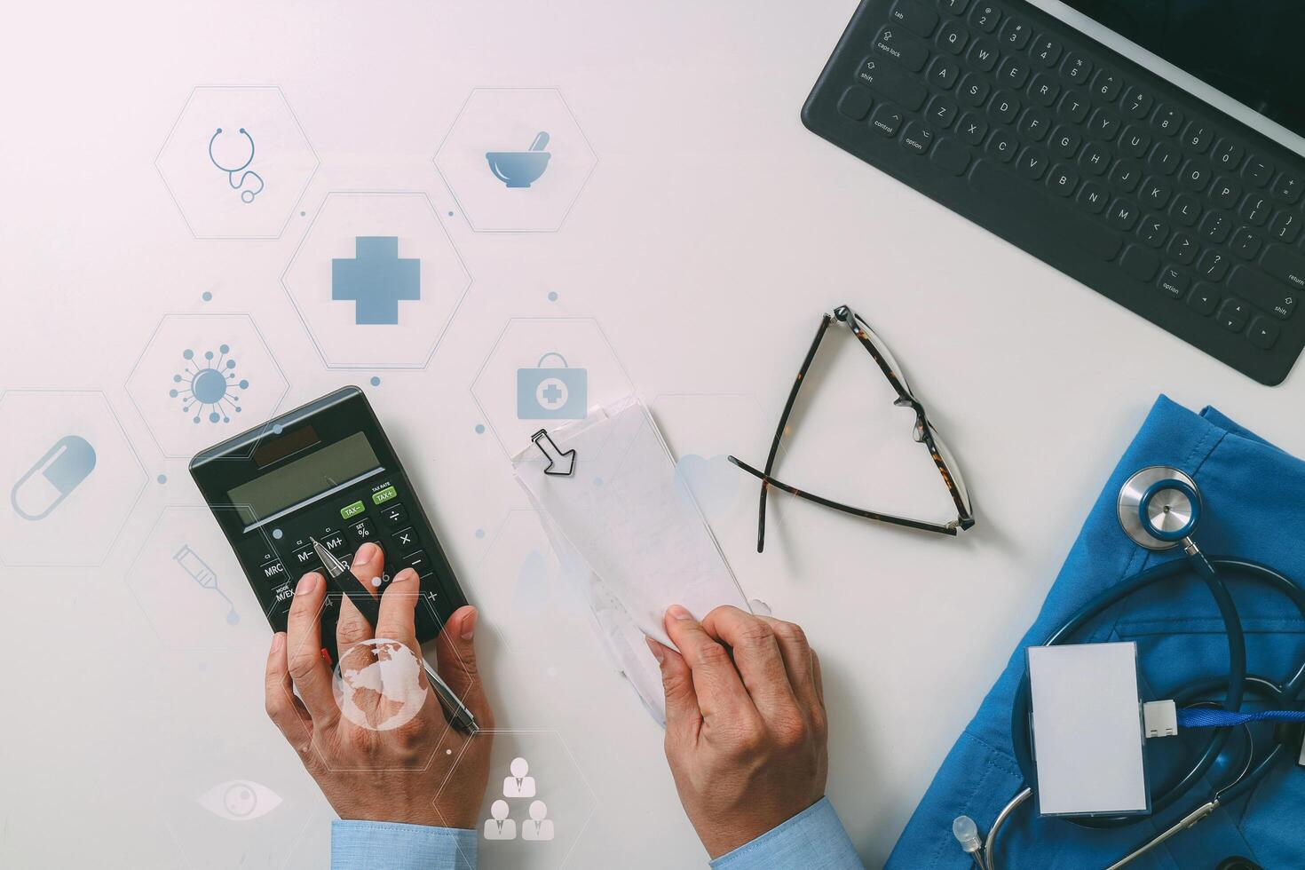 top view of Healthcare costs and fees concept.Hand of smart doctor used a calculator for medical costs in modern hospital with VR icon diagram photo