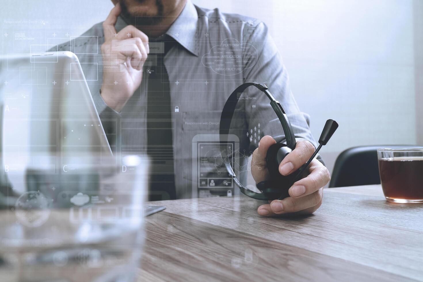 business man using VOIP headset with digital tablet computer docking smart keyboard, concept communication, it support,on wood desk photo