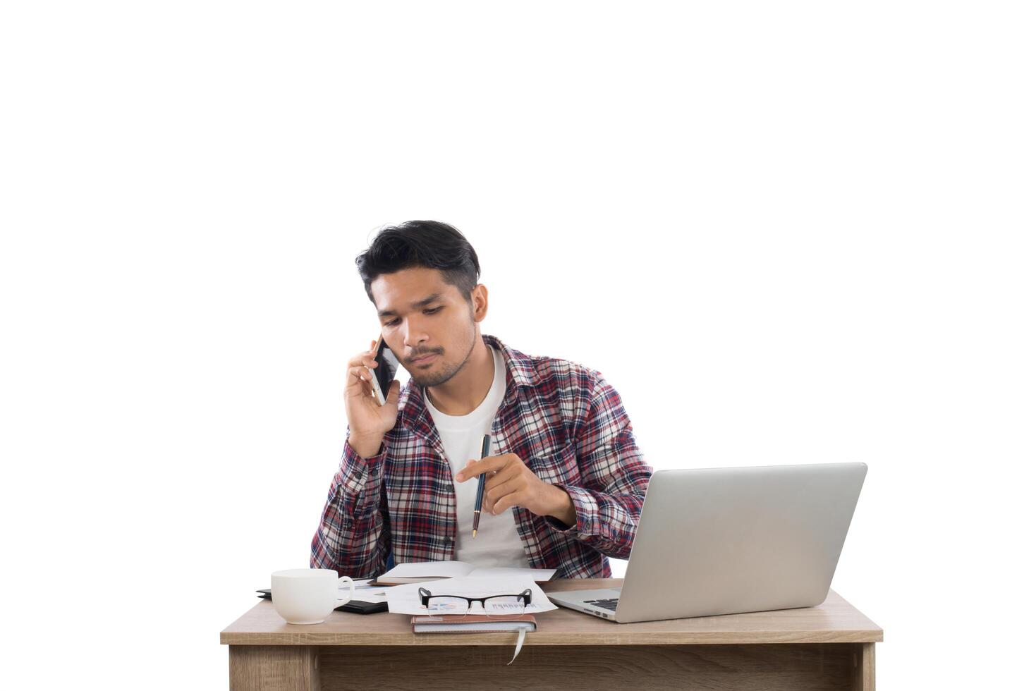 Businessman talking on the phone while work with laptop in the office isolated on white background. photo