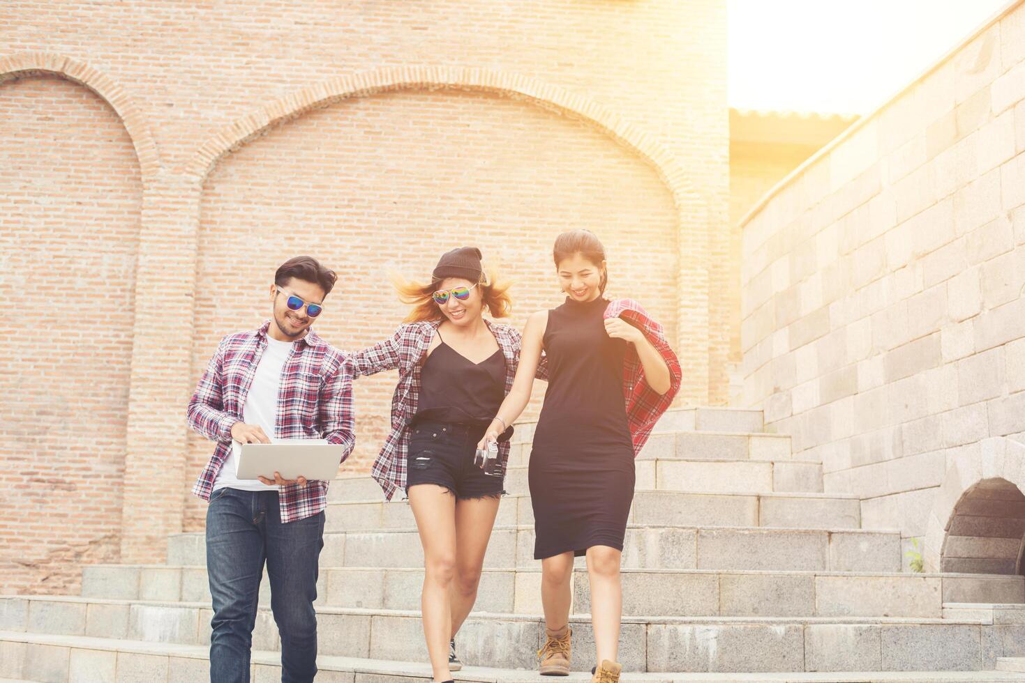 Group of happy hipster teenage students walking down the stairs while talking together. photo