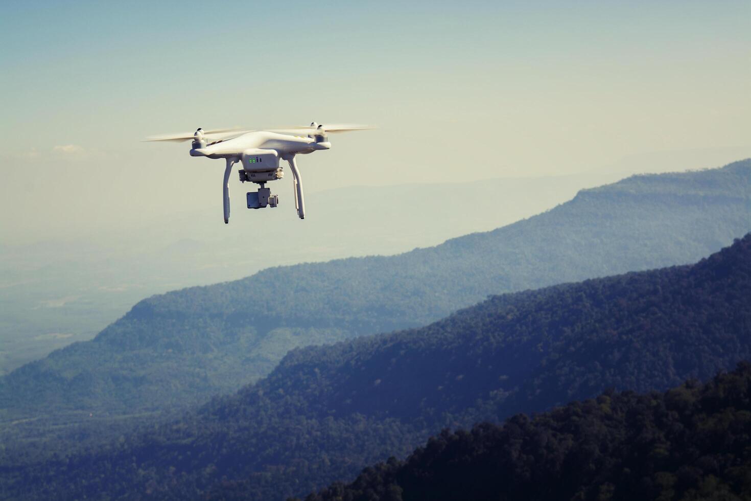 drone volador con cámara en la montaña foto