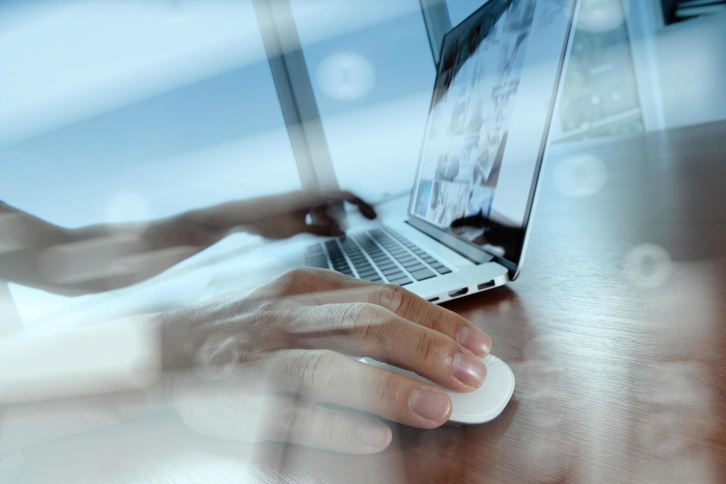 double exposure of business man hand working on laptop computer on wooden desk as concept photo