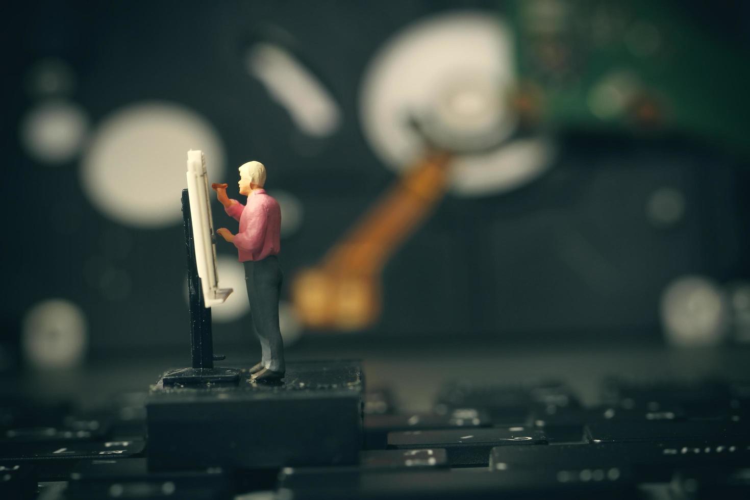 Big data concept-miniature engineer working with drafting table with open hard disk background photo