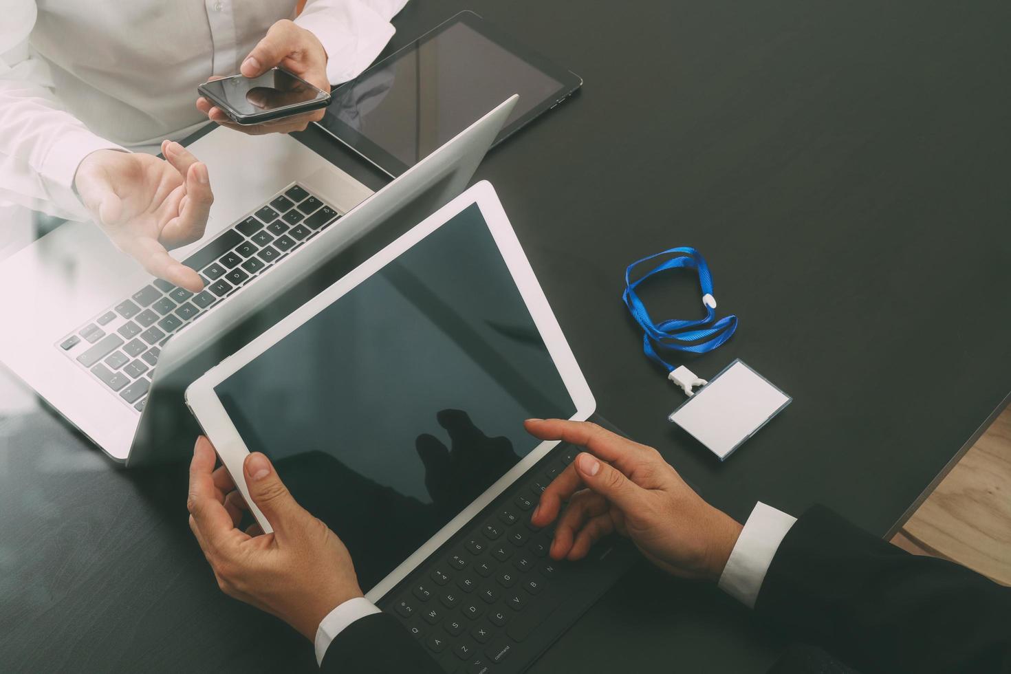 co working team meeting concept,businessman using smart phone and digital tablet and laptop computer and name tag in modern office photo