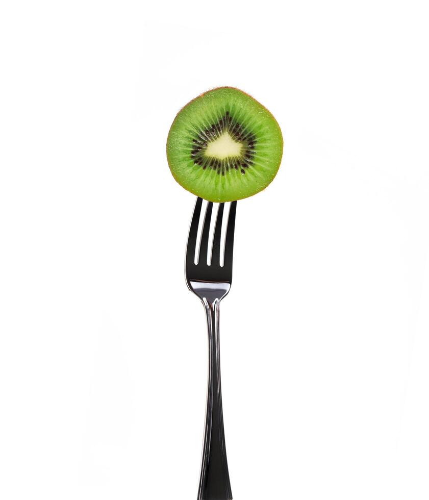 slice kiwi pierced on a fork over white background photo