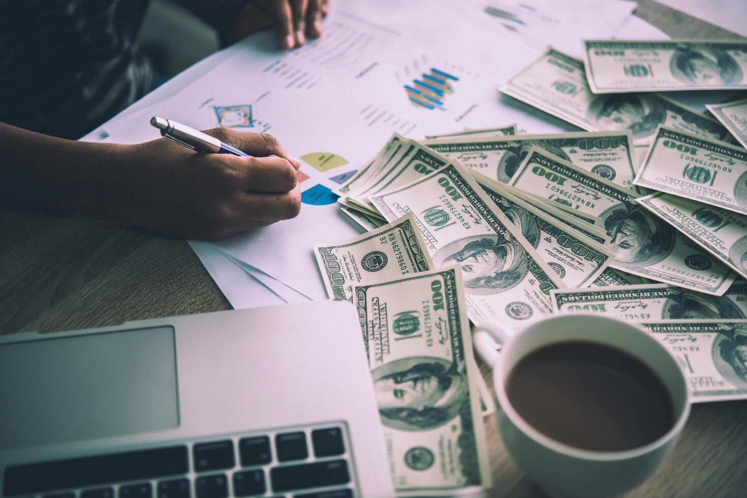 Working place of trader. The table covered by cash notes, keyboard and financial charts. Business financial working. photo