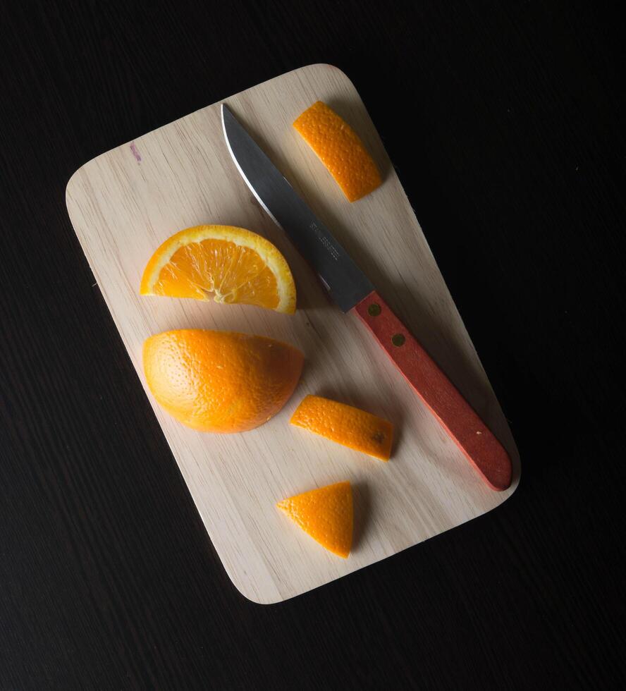 vista superior rodaja de fruta naranja en una tabla de cortar de madera foto