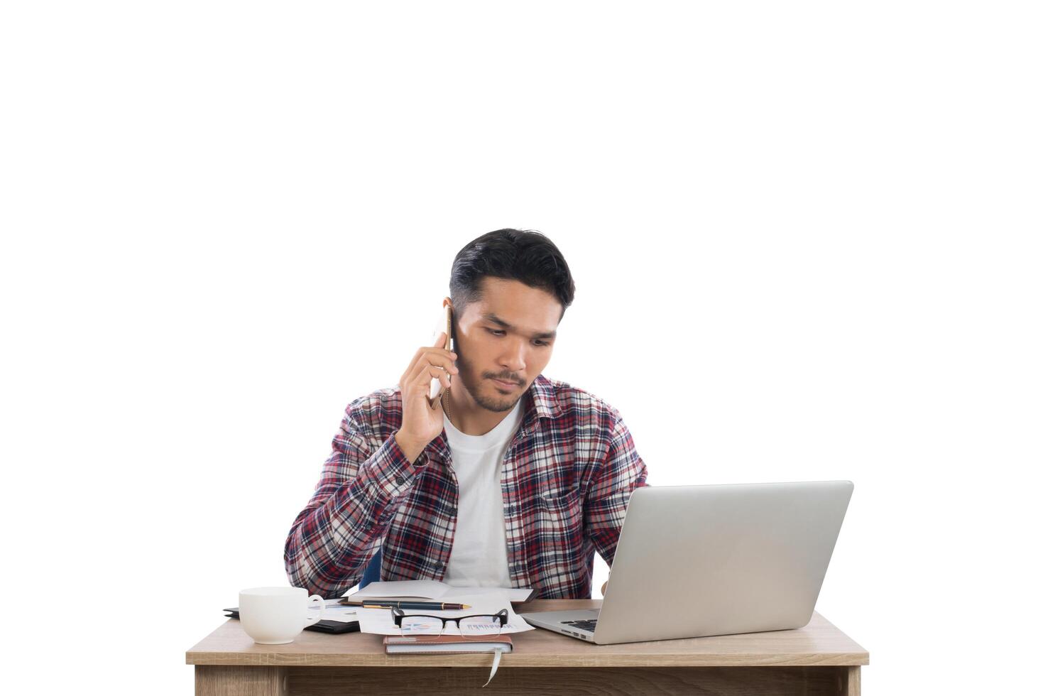 Businessman talking on the phone while work with laptop in the office isolated on white background. photo