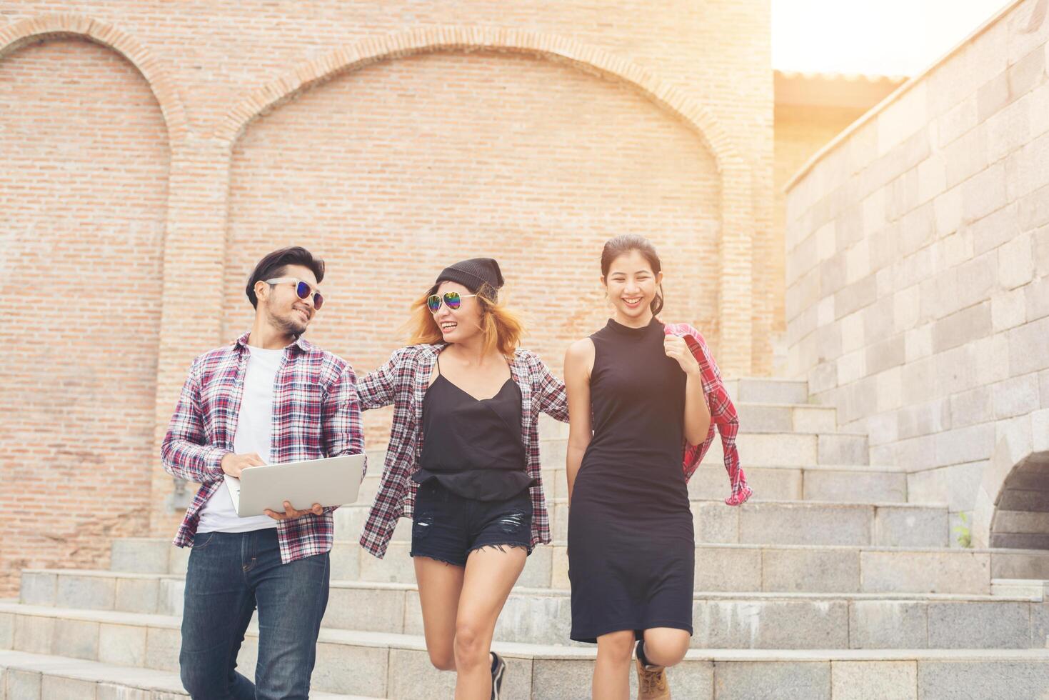 Group of happy hipster teenage students walking down the stairs while talking together. photo