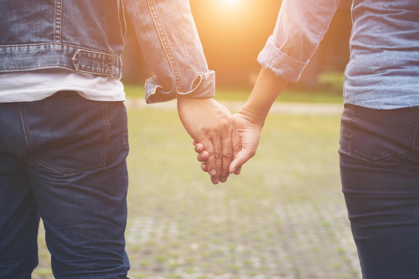 Close-up of loving couple holding hands while walking outdoor, Couple in love concept. photo