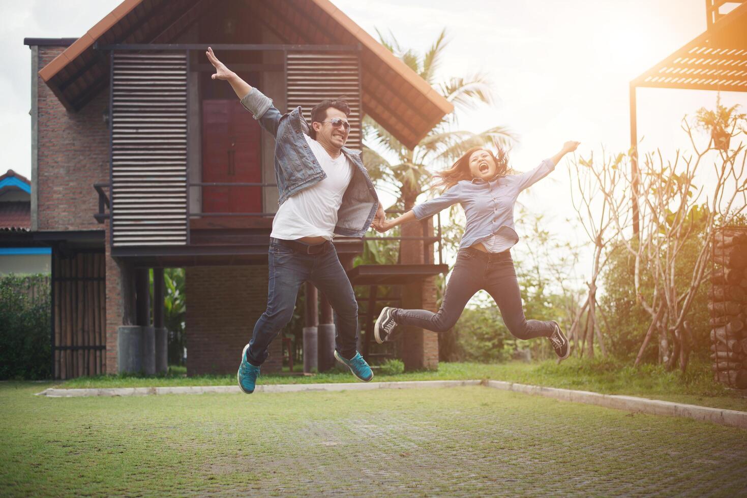 Hipster couple jumping high in the countryside. Couple in love concept. photo