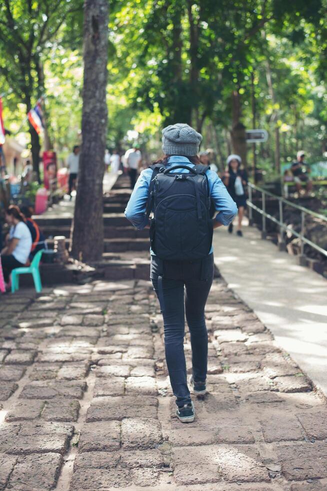 Young attractive woman tourist with backpack coming to ancient phanom rung temple in thailand. photo