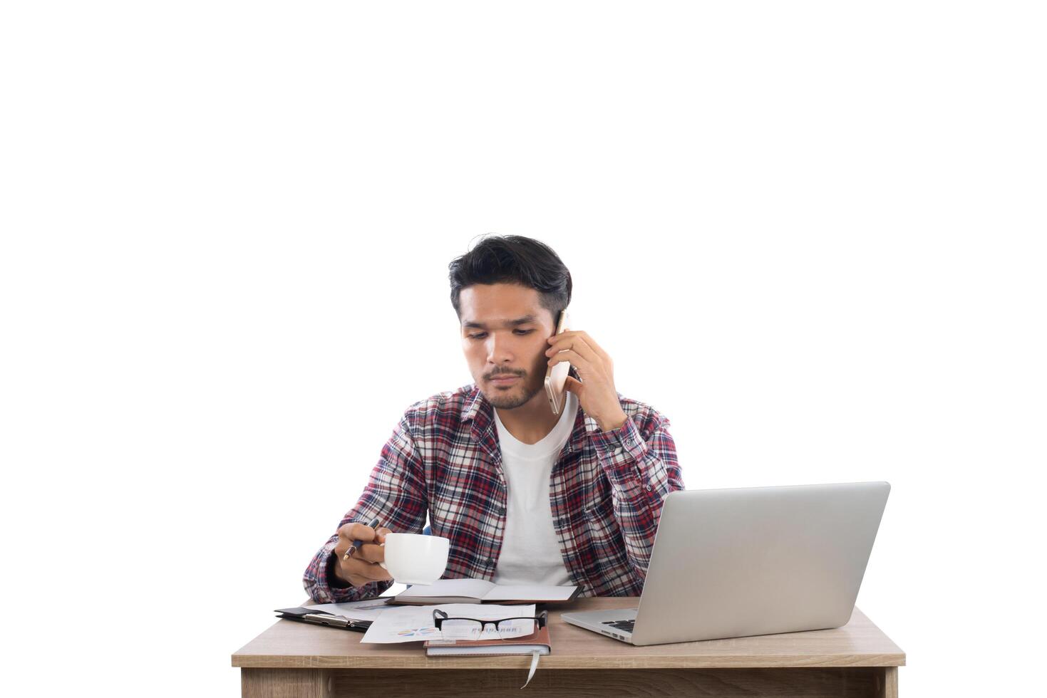 Businessman talking on the phone while work with laptop in the office isolated on white background. photo