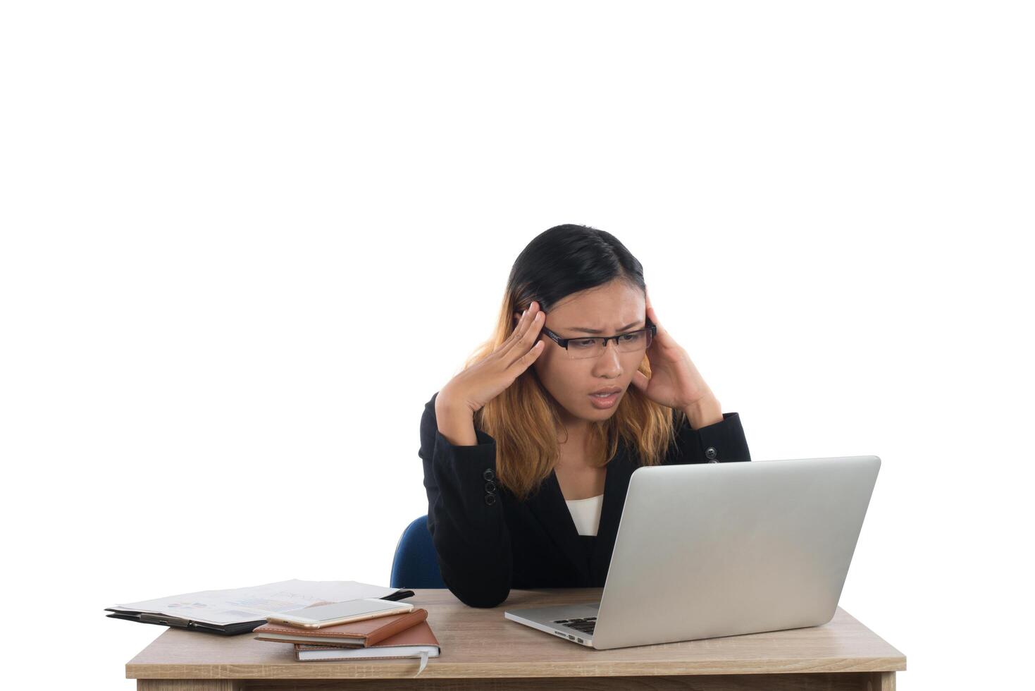 Stressed young business woman at the desk with a laptop isolated on white background. photo