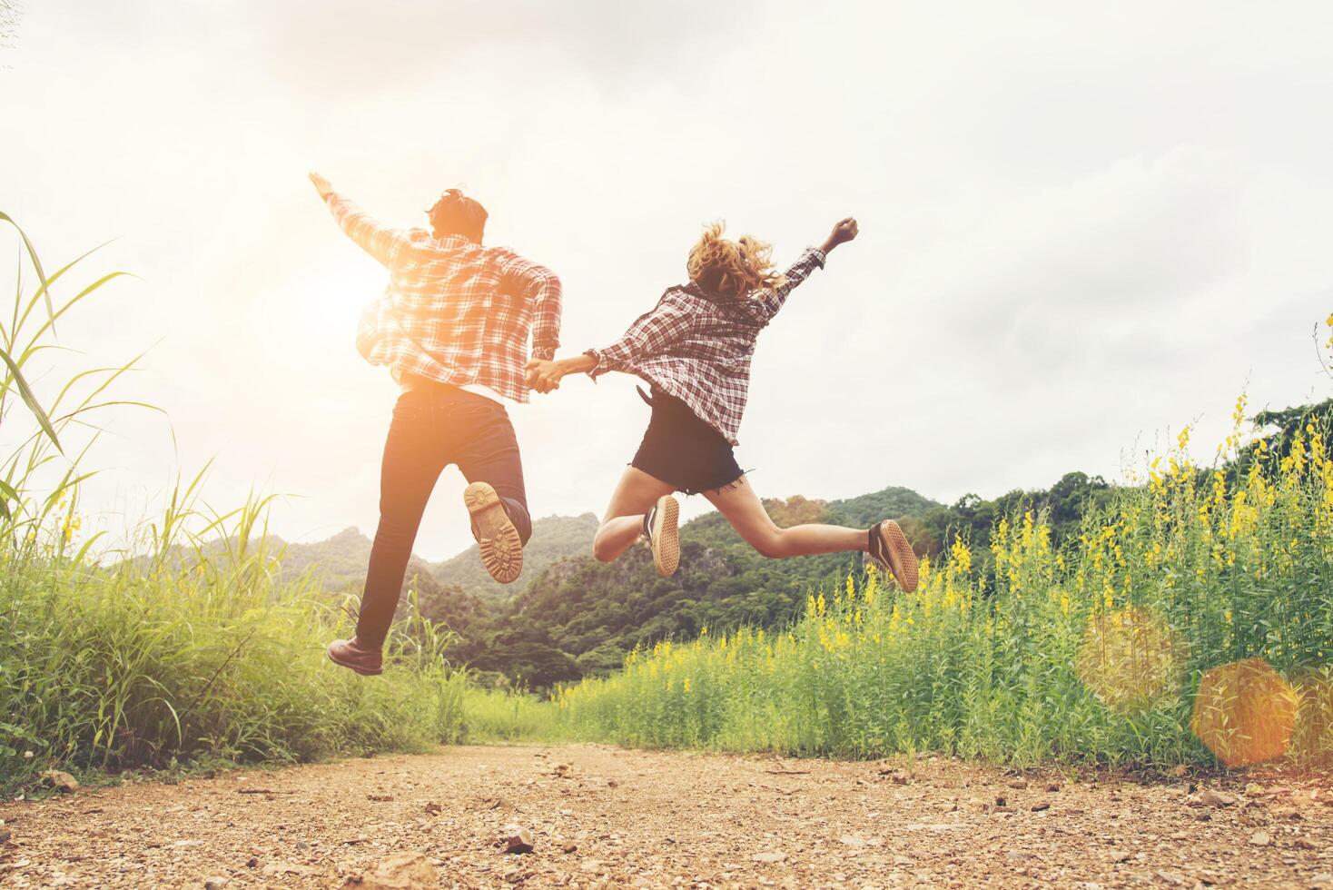 Hipster Teenagers Jumping at the flower field,Happy time,enjoy life ...