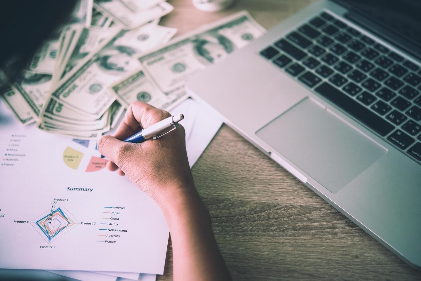 Working place of trader. The table covered by cash notes, keyboard and financial charts. Business financial working. photo