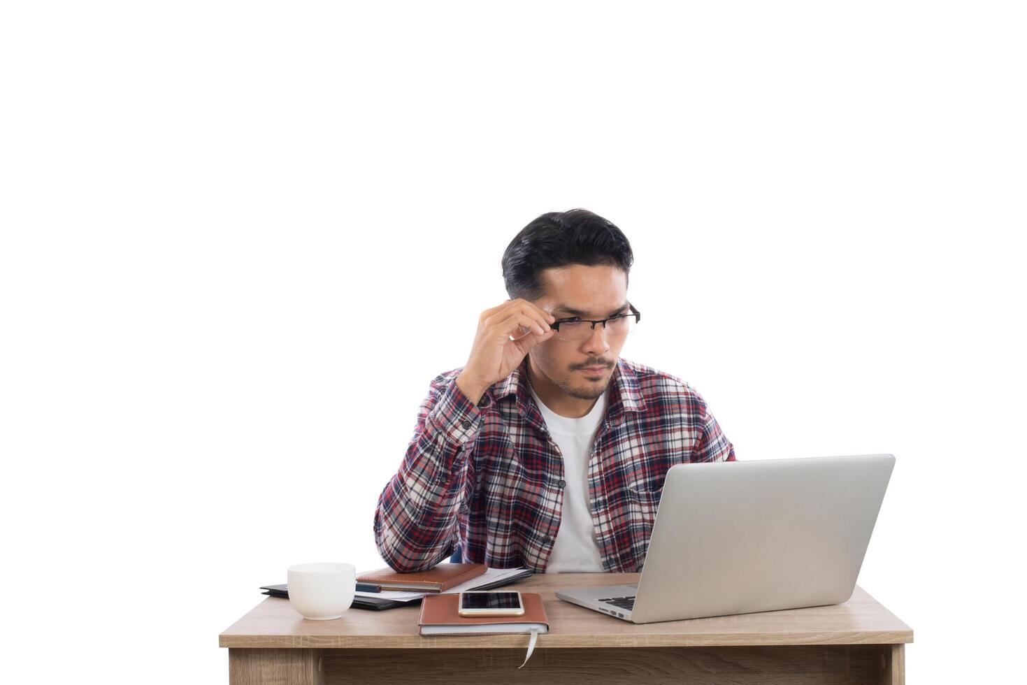 Young businessman working on laptop isolated on white background. photo