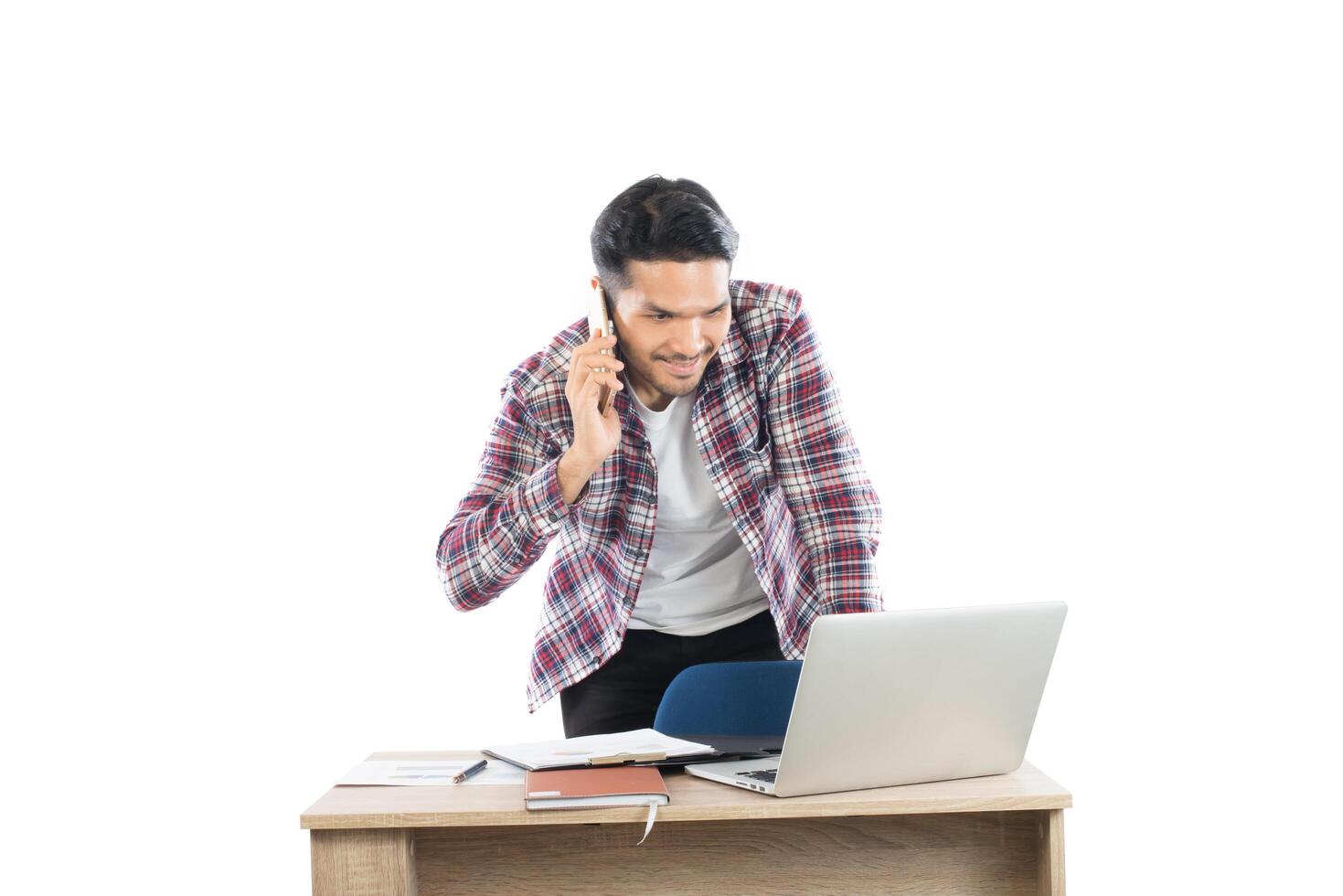 Young businessman talking on phone while working at laptop in office, Busy time with work isolated on white background. photo