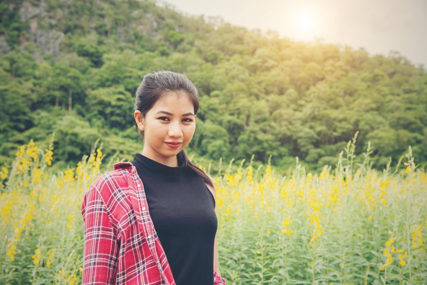 Happy young beautiful woman enjoying summer in yellow flower field at sunset. photo