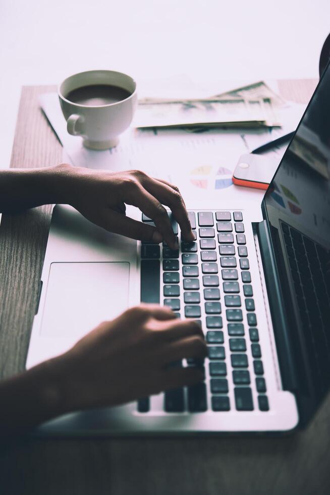 cerca de las manos de una mujer de negocios escribiendo en una computadora portátil. foto