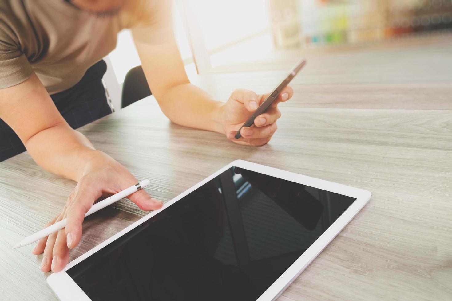 vista superior de la mano del diseñador que trabaja con una tableta digital en un escritorio de madera como concepto de diseño web receptivo foto