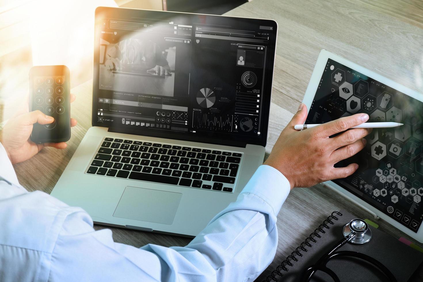 Doctor working with digital tablet and laptop computer with smart phone in medical workspace office and video conferance as concept photo