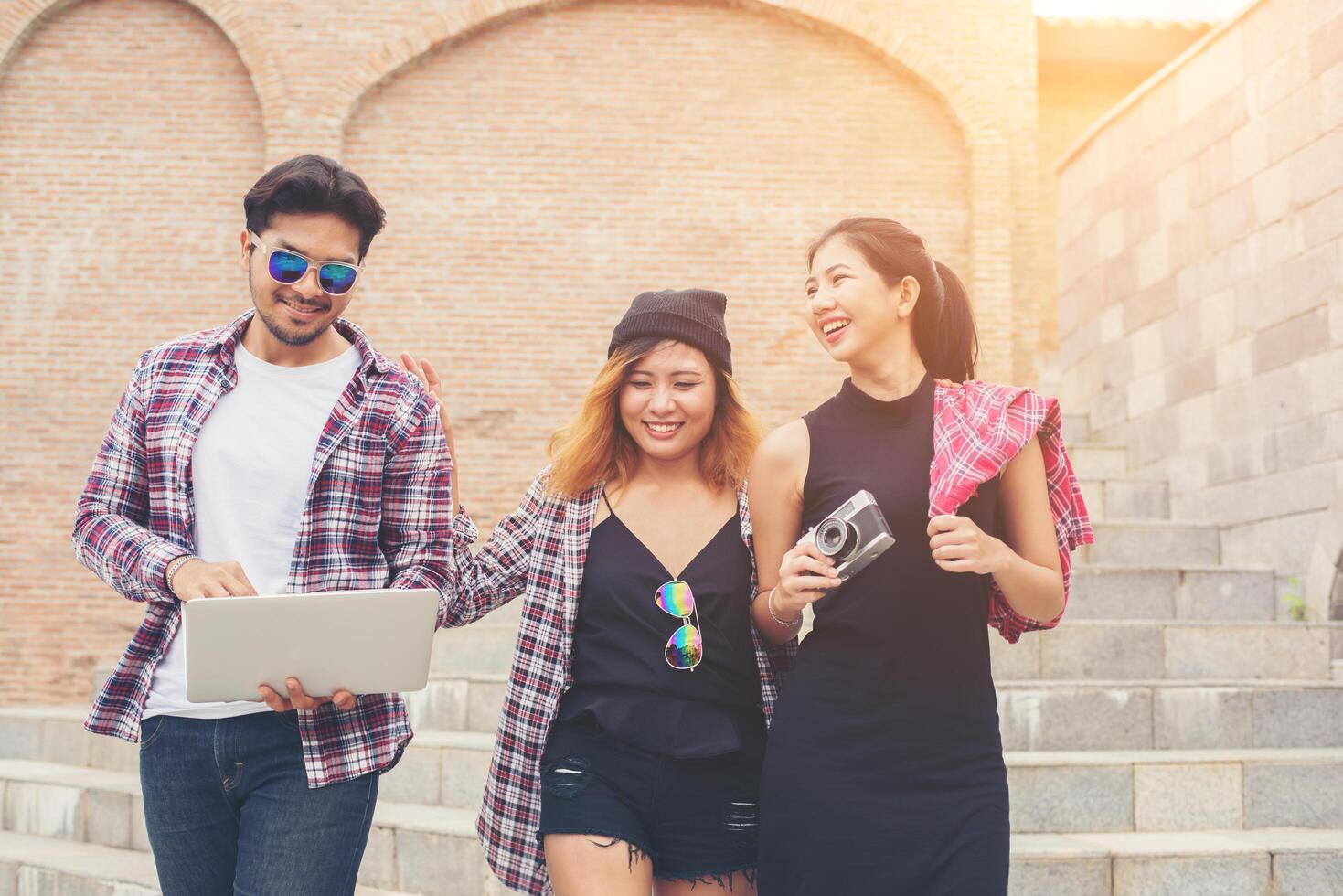 Group of happy hipster teenage students walking down the stairs while talking together. photo