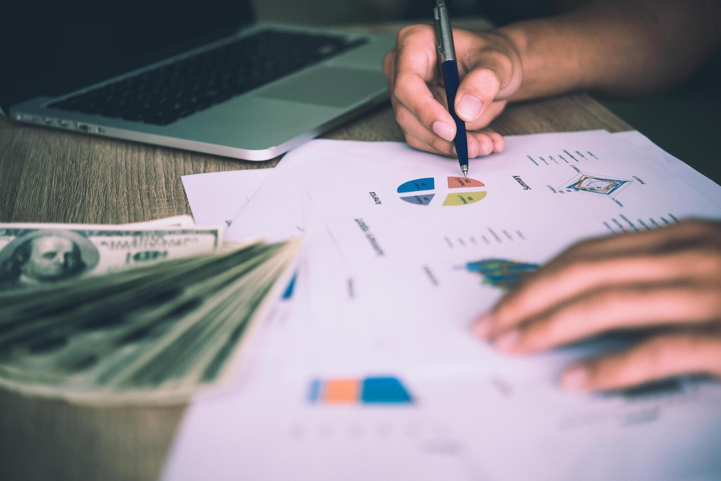 Working place of trader. The table covered by cash notes, keyboard and financial charts. Business financial working. photo