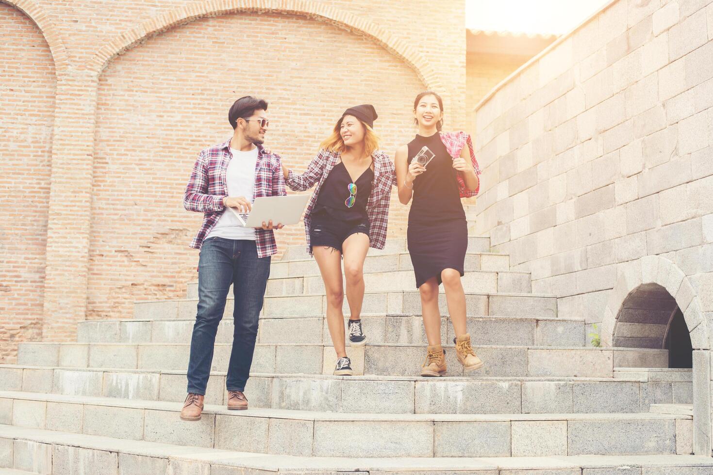 Group of happy hipster teenage students walking down the stairs while talking together. photo