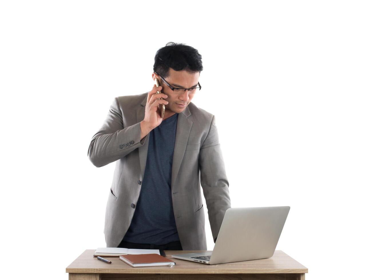 Businessman working on laptop and calling on phone, white background. photo