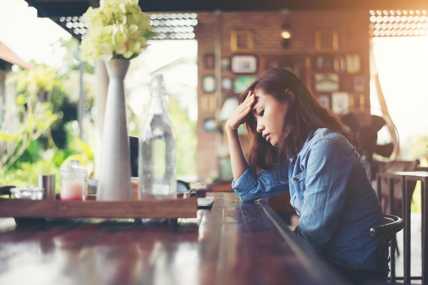 Young woman sitting in a cafe with her laptop, Stressful for work. photo