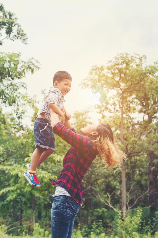 Mother throws the son in her arms, in the park happy time,enjoy together. photo