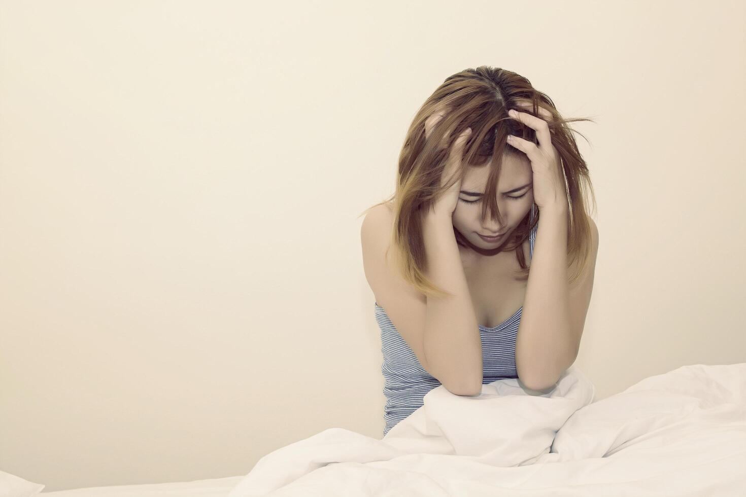 Women thinking of something on the white bed. photo