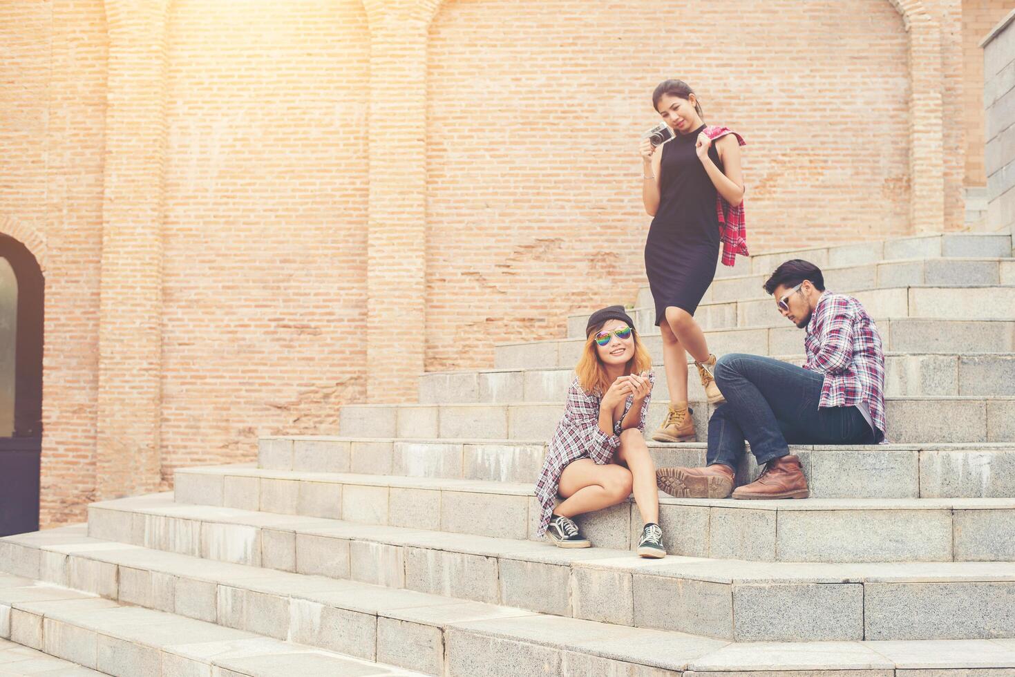 grupo de estudiantes hipster sentados en una escalera hablando y relajándose juntos después de la escuela. foto